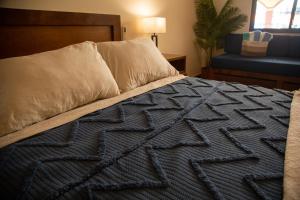 a bed with a blue blanket and pillows on it at Estancia 102 in La Paz +2 photos