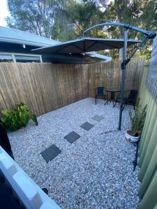 a patio with a black umbrella on a fence at Central Gem in Dunsborough