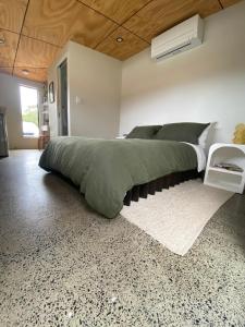 Un dormitorio con una gran cama verde y una alfombra en Central Gem en Dunsborough