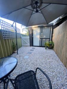 a patio with a table and chairs and an umbrella at Central Gem in Dunsborough