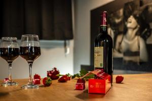 Una botella de vino y dos copas en una mesa en Cocon Sensuel - 50 Nuances - Les Cocons de Nath, en Montbéliard