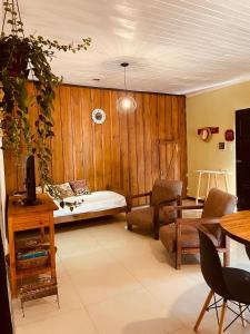 ein Wohnzimmer mit einem Bett und einem Tisch in der Unterkunft Casa Araucarias Refugio Natural en la Ciudad in Posadas