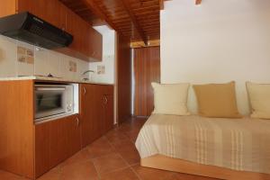 a small bedroom with a bed and a kitchen at George SkyrosStudios in Skiros