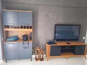 Zimmer mit einem TV und einem Schreibtisch mit einem TV. in der Unterkunft Cobertura Guarujá in Guarujá