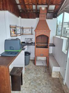 uma cozinha com um forno de tijolos num quarto em Cobertura Guarujá no Guarujá