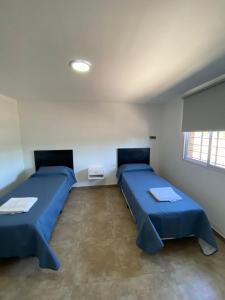 Habitación con 2 camas y ventana en Departamentos Los Cardos en San Rafael