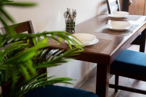 a wooden table with two plates and a plant at Estancia 105 in La Paz