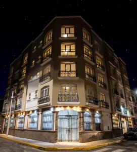 a tall building with windows and balconies at night at Sol Plaza Hotel in Puno