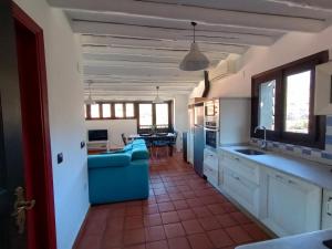eine Küche mit einem blauen Sofa und einem Esszimmer in der Unterkunft Sésamo Apartamento in Hervás