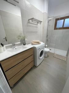 a bathroom with a sink and a washing machine at Apartamento RODA - Candelaria in Candelaria