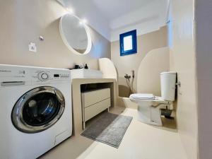 a bathroom with a washing machine and a toilet at Paros Home in Kampos Paros