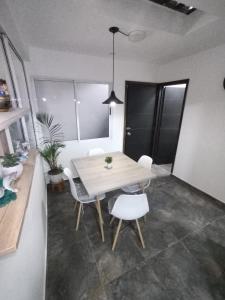 a dining room with a table and white chairs at Hospedaje Estrella de Luna in Bogotá