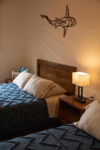 a bedroom with two beds and a table with a lamp at Estancia 105 in La Paz