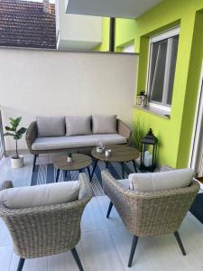 a patio with two tables and a couch and chairs at Studio apartman Aurora in Đakovo