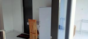 uma cozinha com um frigorífico e uma cadeira de madeira em Giri Homestay em Amed