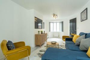 ein Wohnzimmer mit einem blauen Sofa und Stühlen in der Unterkunft Luxury Executive Home in Birmingham in Birmingham