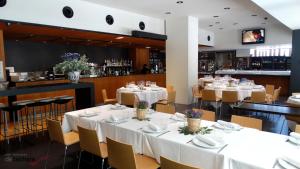 a restaurant with white tables and chairs and a bar at Blu Hotel Almansa in Almansa