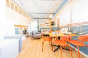 a dining room with a table and orange chairs at Tokyo Skytree sta 2min walk, 2stop Asakusa sta-Stay SUU & Cafe- in Tokyo