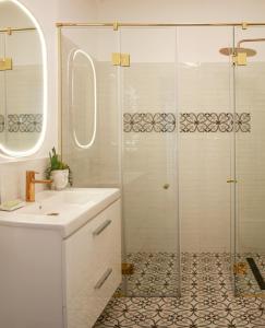 un bagno bianco con doccia e lavandino di Premium Central Apartment a Braşov Altre 9 foto