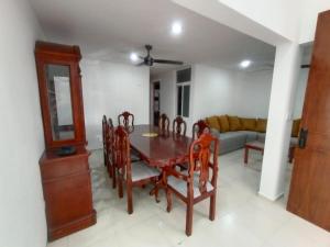 uma sala de jantar com uma mesa e cadeiras e um sofá em Casa de 3 recamaras frente al parque em Mérida