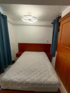 a small bedroom with a bed and a ceiling at Casa de 3 recamaras frente al parque in Mérida