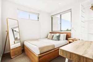 a small bedroom with a bed and a window at Modern 2BD in Trendy Inner West in Sydney