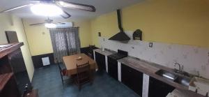 eine Küche mit einer Theke, einem Tisch und einem Waschbecken in der Unterkunft LIA in Salta