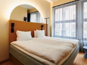 1 dormitorio con 1 cama grande y ventana grande en Scandic GO, Upplandsgatan 4, en Estocolmo