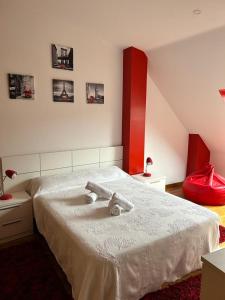 1 dormitorio con 1 cama blanca grande con detalles en rojo en Acogedor apartamento ático en el centro de O Porriño, en Porriño