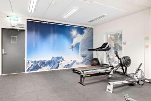 Habitación con una pared con una imagen de montaña en Aiden by Best Western Harstad Narvik Airport en Harstad