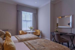 a hotel room with two beds and a table at Oatlands Park Hotel in Weybridge +126 photos