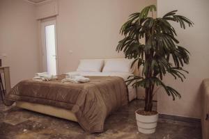 a bedroom with a bed and a potted plant at Campania Apartment Pompei Luxury - 150m dalla stazione - 5km da Pompei in Poggiomarino
