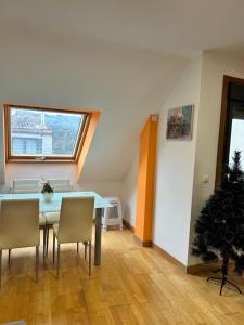 un comedor con mesa y sillas y un árbol de Navidad en Acogedor apartamento ático en el centro de O Porriño, en Porriño