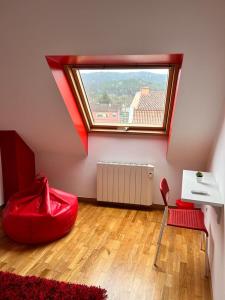 a room with a red bean bag chair and a window at Acogedor apartamento ático en el centro de O Porriño in Porriño