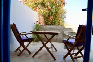 two chairs and a wooden table on a patio at Paros Home in Kampos Paros +24 photos