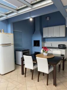 uma cozinha com uma mesa e cadeiras e um frigorífico em Casa do Jardim em Curitiba
