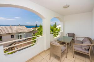 Un balcón con mesa y sillas y vista al mar. en Apartments Obradović, en Dramalj 17 fotos más