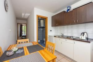 una cocina y comedor con una mesa y una cocina gmaxwell gmaxwell gmaxwell en Apartments Obradović, en Dramalj