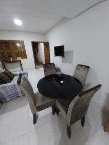 a dining room table and chairs in a room at duplex aconchegante in Tramandaí