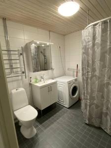 y baño con lavamanos y lavadora. en Cozy apartment in Rastila, en Helsinki