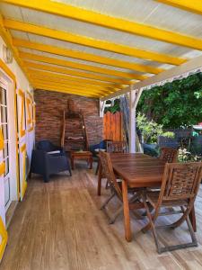 a wooden table and chairs on a patio at Villa KER IGUANE Terre de Haut Les saintes in Terre-de-Haut
