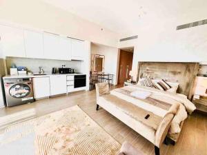 a large bedroom with a large bed and a kitchen at Mayan Studio Apartment in Abu Dhabi