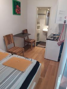 a small room with a bed and a kitchen at Apartment Dahlia Vienna in Vienna