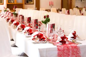 una fila di tavoli bianchi con bicchieri da vino sopra di Hotel Schilcherlandhof a Stainz