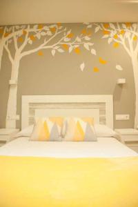 um quarto com uma cama com árvores na parede em Cumbres de los Picos Apartamento Los Abedules em Poo de Cabrales