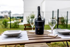 a bottle of wine sitting on a table with glasses at King Size Bed - Free Private Parking - Garden & Terrace - 14min from DisneyLand in Ferrières-en-Brie
