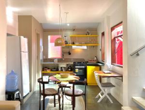 uma pequena cozinha com mesa e cadeiras em casa Encantadora em Florianópolis