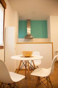 eine Küche mit einem Tisch mit Stühlen und einer Schüssel darauf in der Unterkunft Cumbres de los Picos Apartamento Buhos in Poo de Cabrales