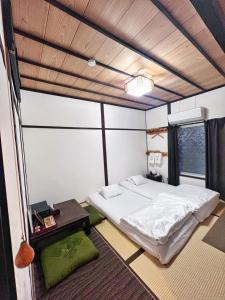 a bedroom with a bed in a room with a window at Bighem Maison in Izumi-Sano