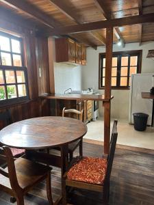 a kitchen with a wooden table and a table and chairs at CHALÉ 50 METROS DA PRAIA- CHALÉS SOLANA in Garopaba
